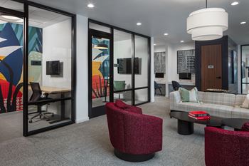 A lounge area with chairs and couches and a table